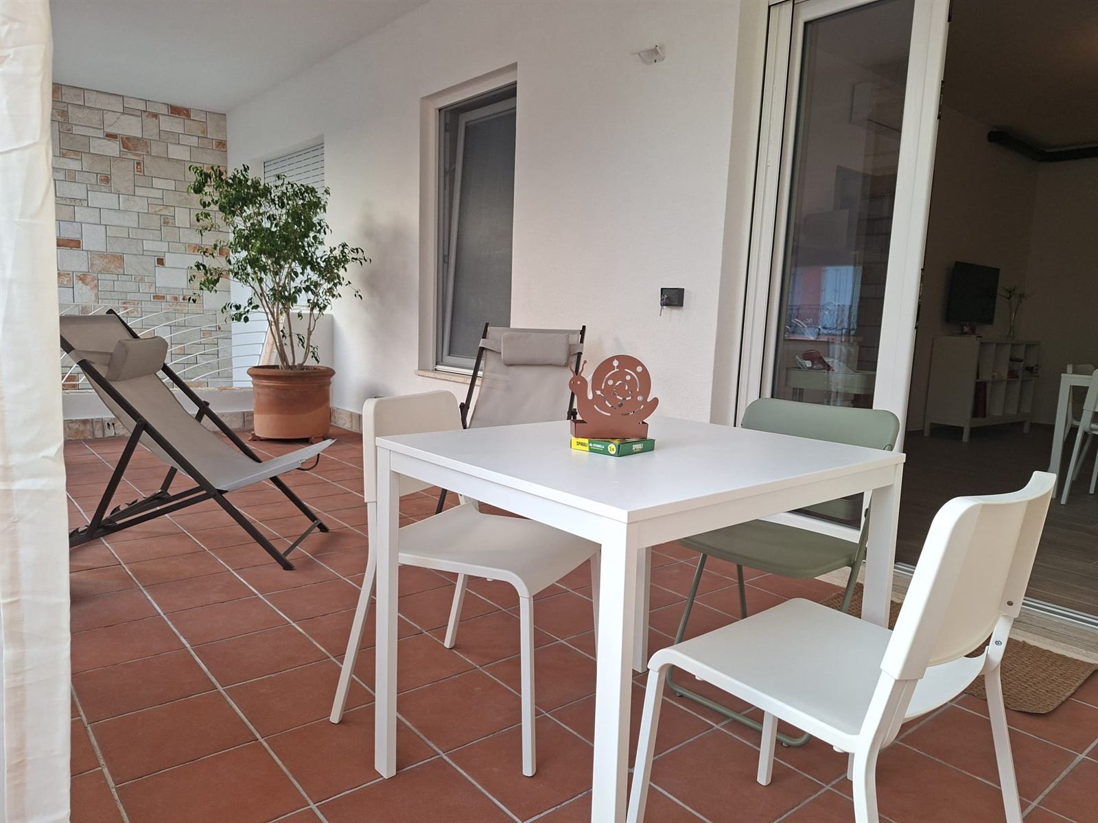 Terrazzo privato di Casa Copé con tavolo, sedie e sdraio