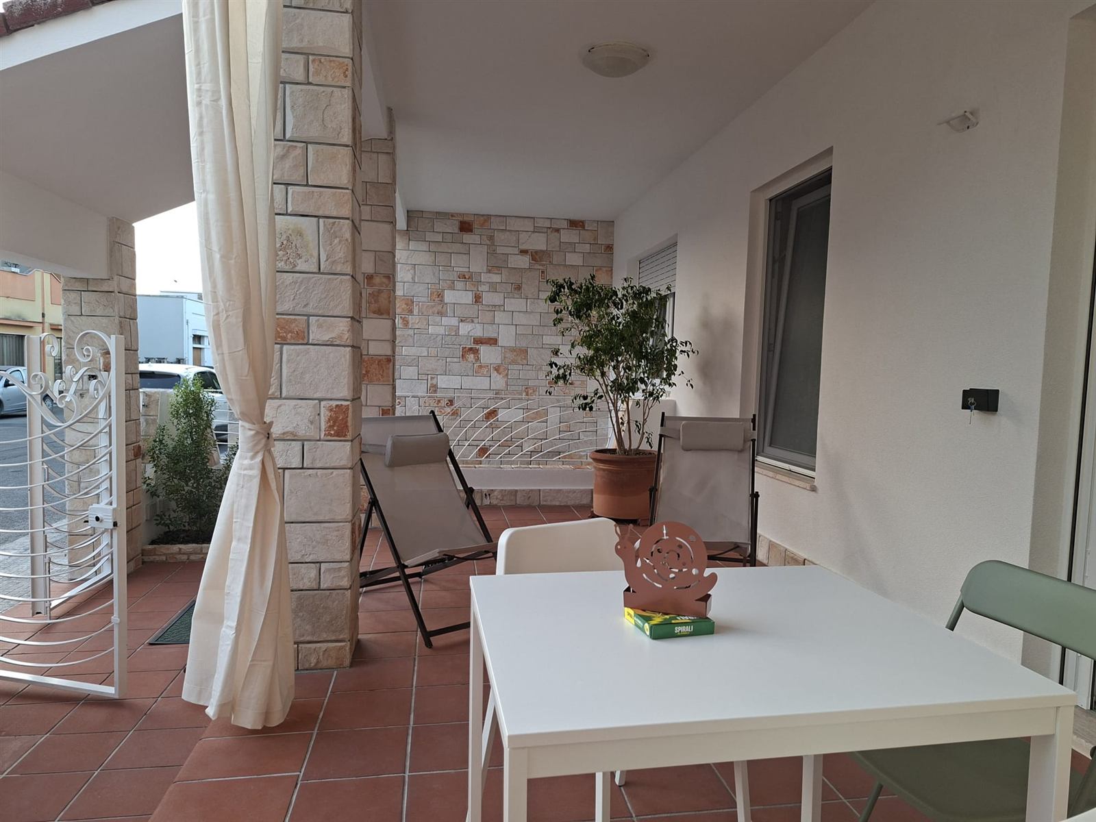 Terrazza privata arredata di Casa Copé con tavolo, sedie e sdraio
